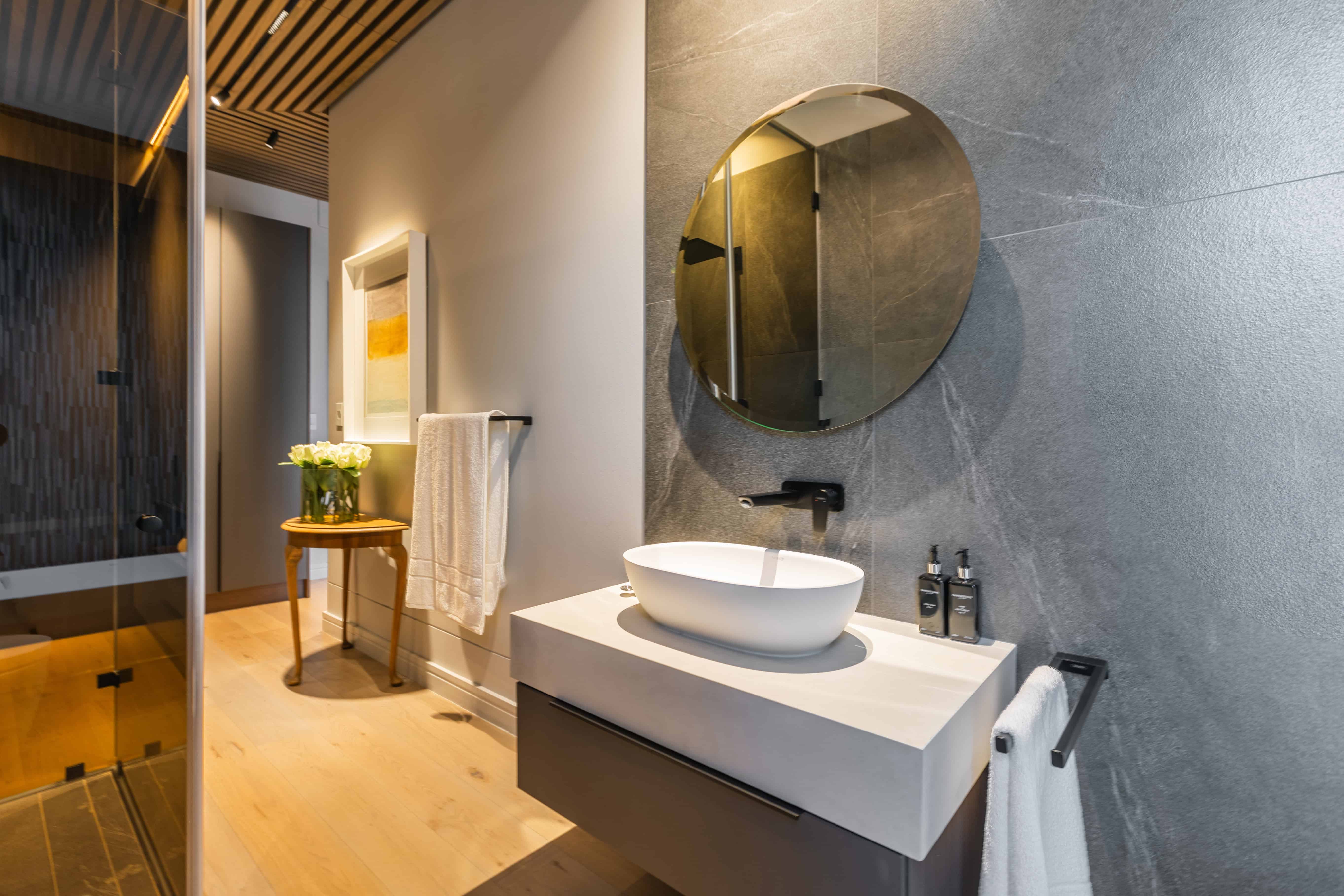 Contemporary ensuite bathroom with freestanding vanity and textured wall, Steyn City residence – Johannesburg interior designer.