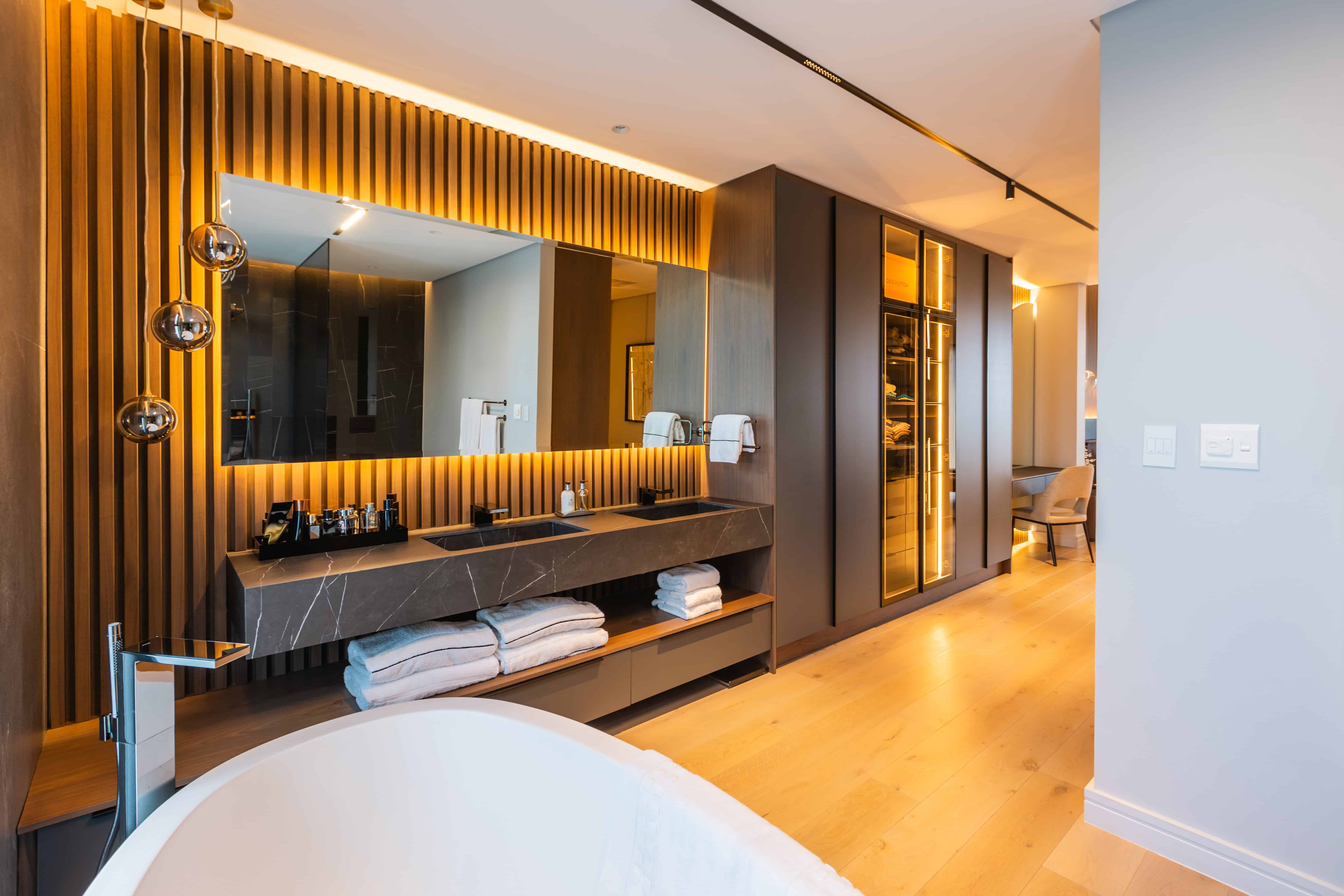 Elegant bedroom featuring natural wood finishes, low bed, and panoramic glazing in Steyn City – Renovatio Interior Design Johannesburg.