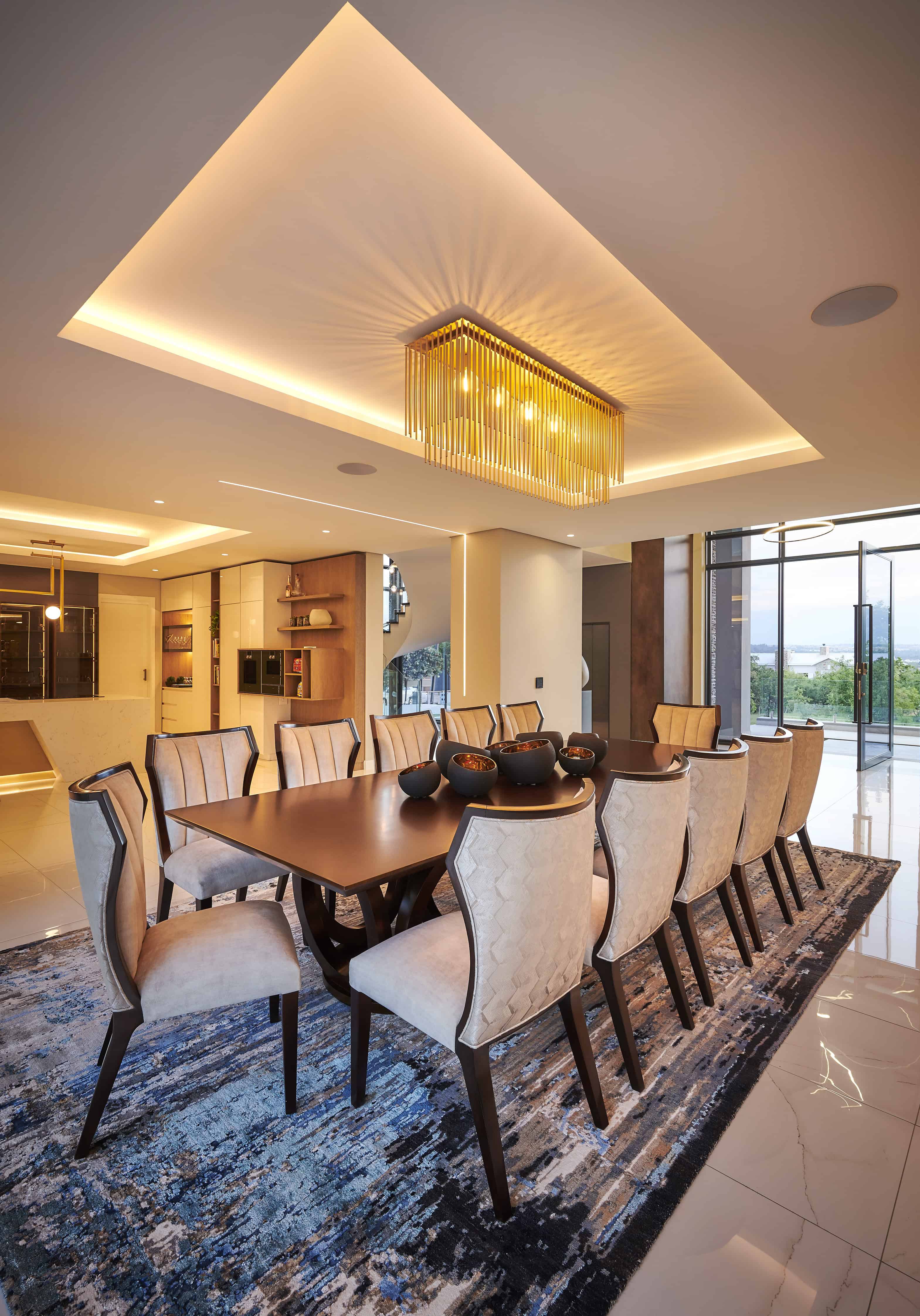 Sophisticated dining area featuring a patterned rug, statement lighting and neutral palette curated by Interior Designer Johannesburg.