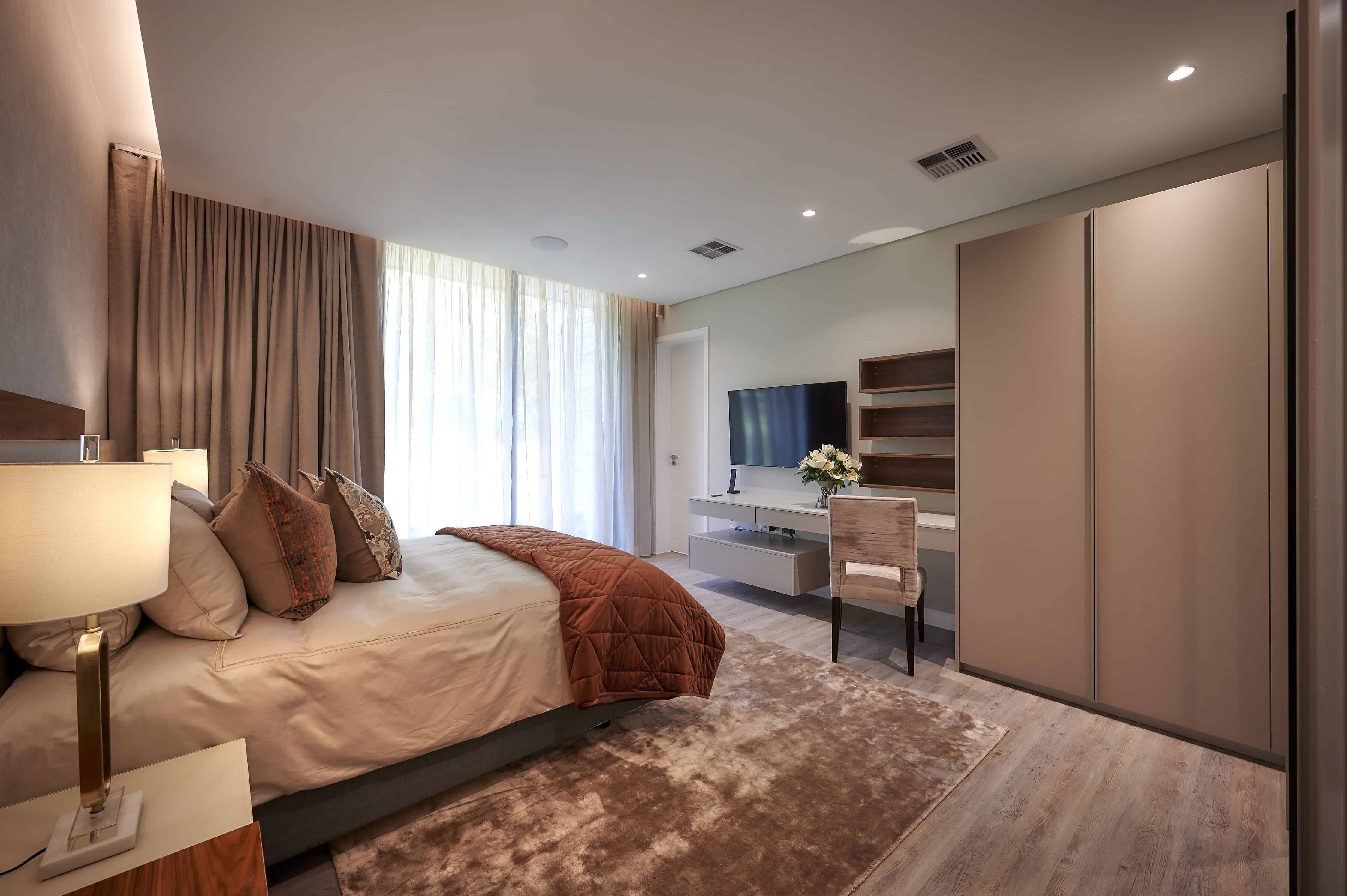 Modern bedroom with large windows, neutral tones and sleek furniture created by Interior Designer Johannesburg.