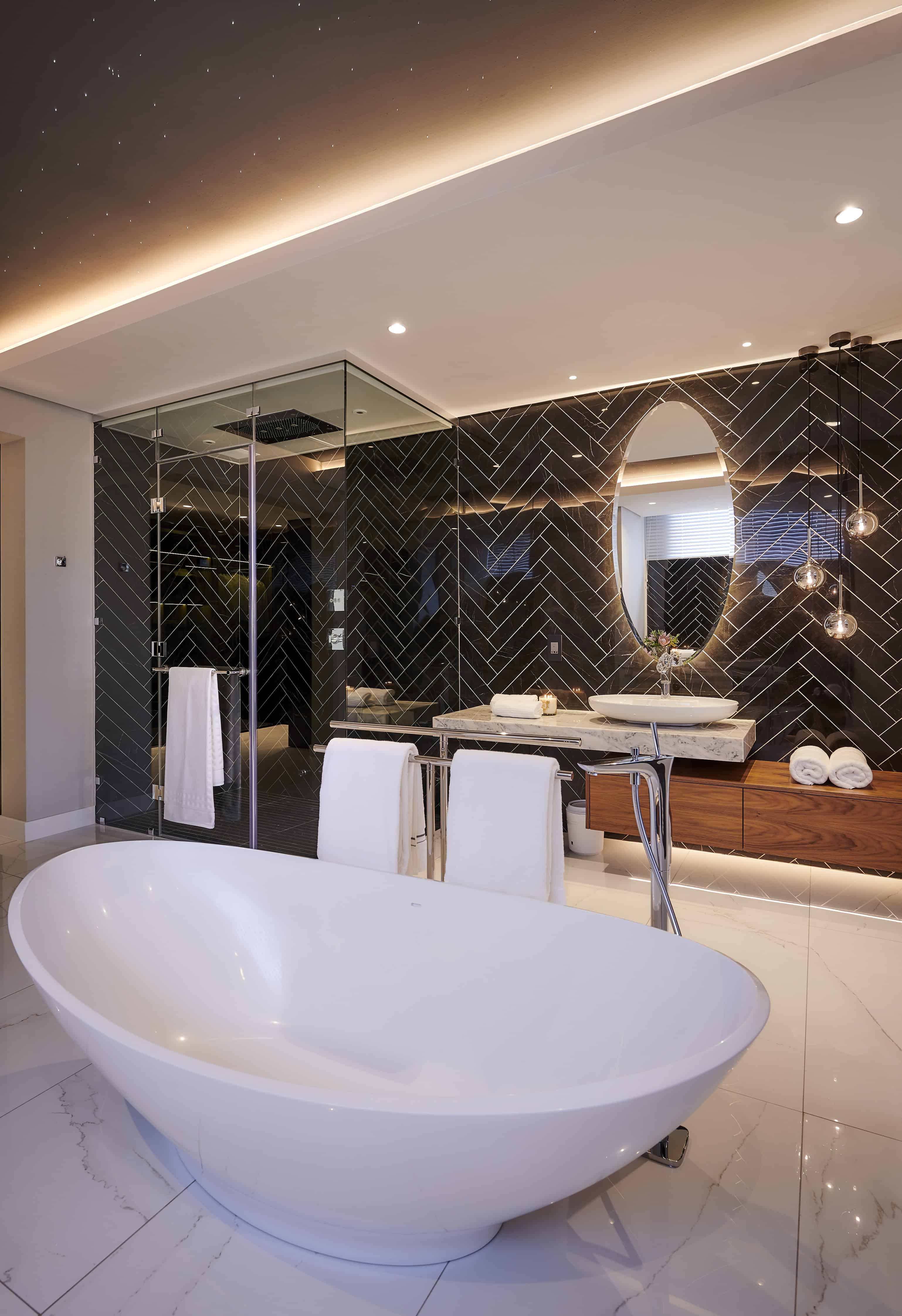 Modern bathroom showcasing a freestanding bathtub, large mirror and elegant fixtures by Interior Designer Johannesburg.