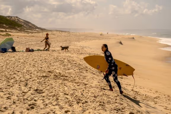 Maya Gabeira on the beach with her surfboard