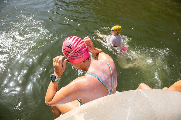Two women enter Saguaro Lake.
