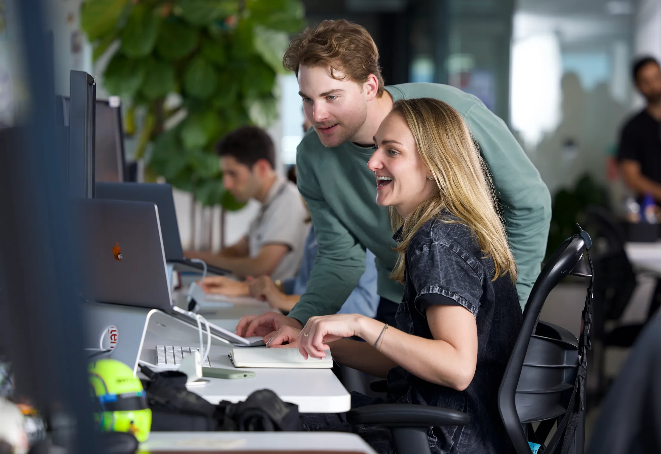 A diverse group of individuals collaborating around a table, engaged in discussions and working on projects.