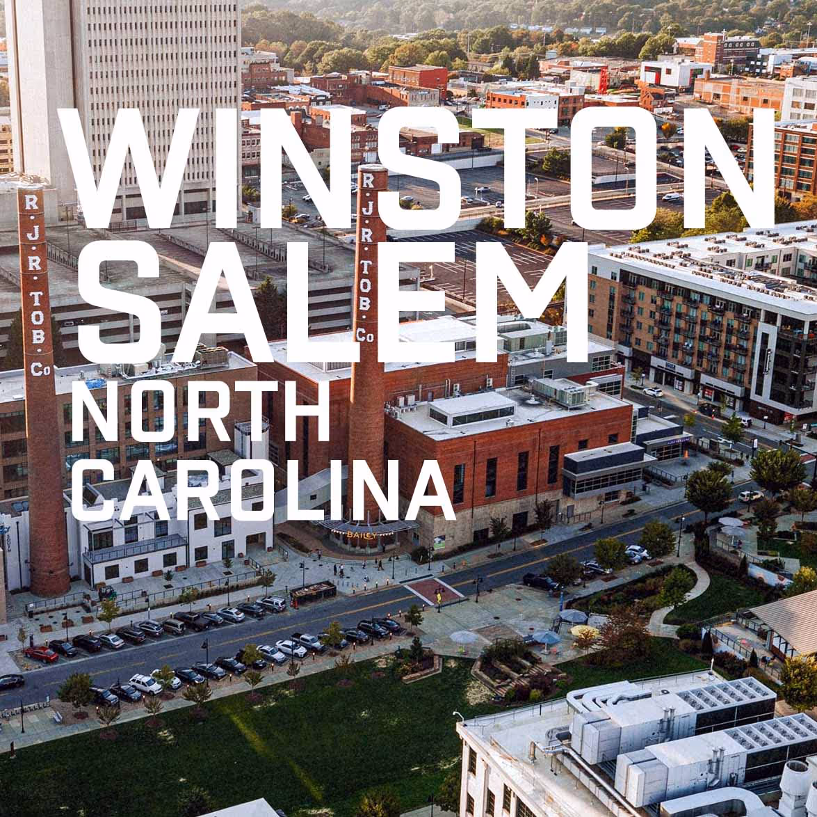 Aerial view of downtown Winston-Salem, North Carolina, featuring historic brick buildings with tall smokestacks labeled RJ R Tob Co.