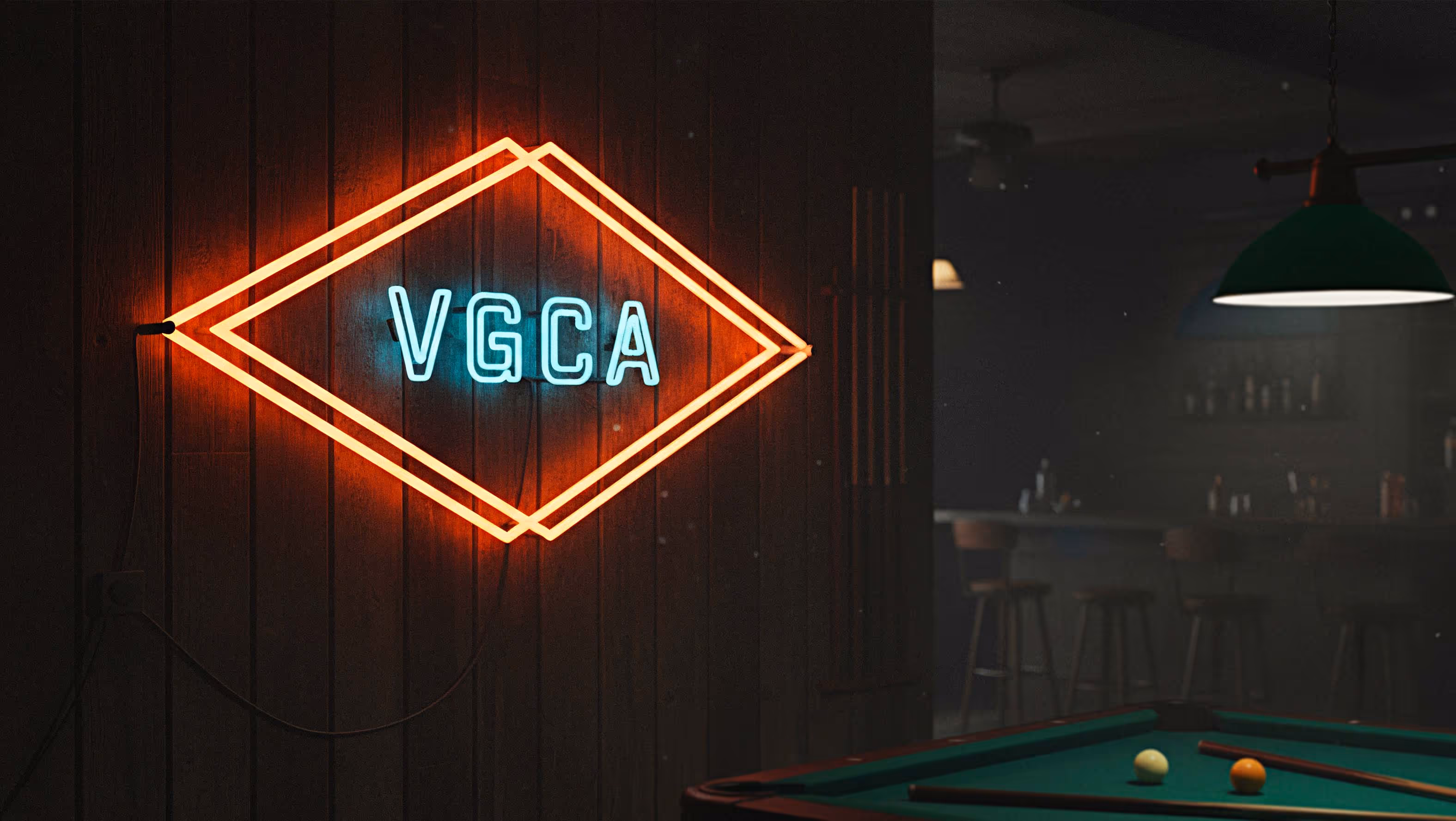 Blue neon sign reading VGCA framed by an orange neon diamond shape on a dark wooden wall beside a dimly lit pool table and bar area.