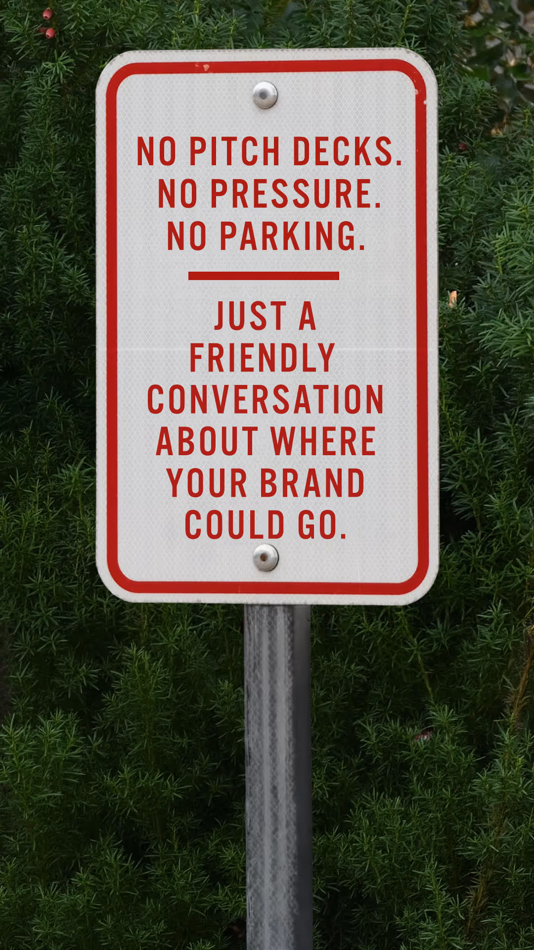 White sign with red border and text stating no pitch decks, no pressure, no parking, just a friendly conversation about where your brand could go.
