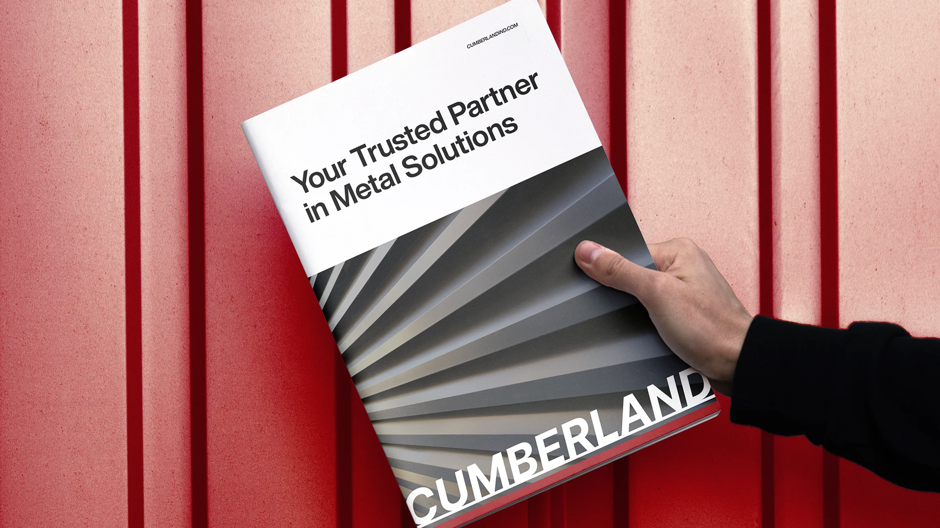 Cumberland brand brochure against a red metal wall