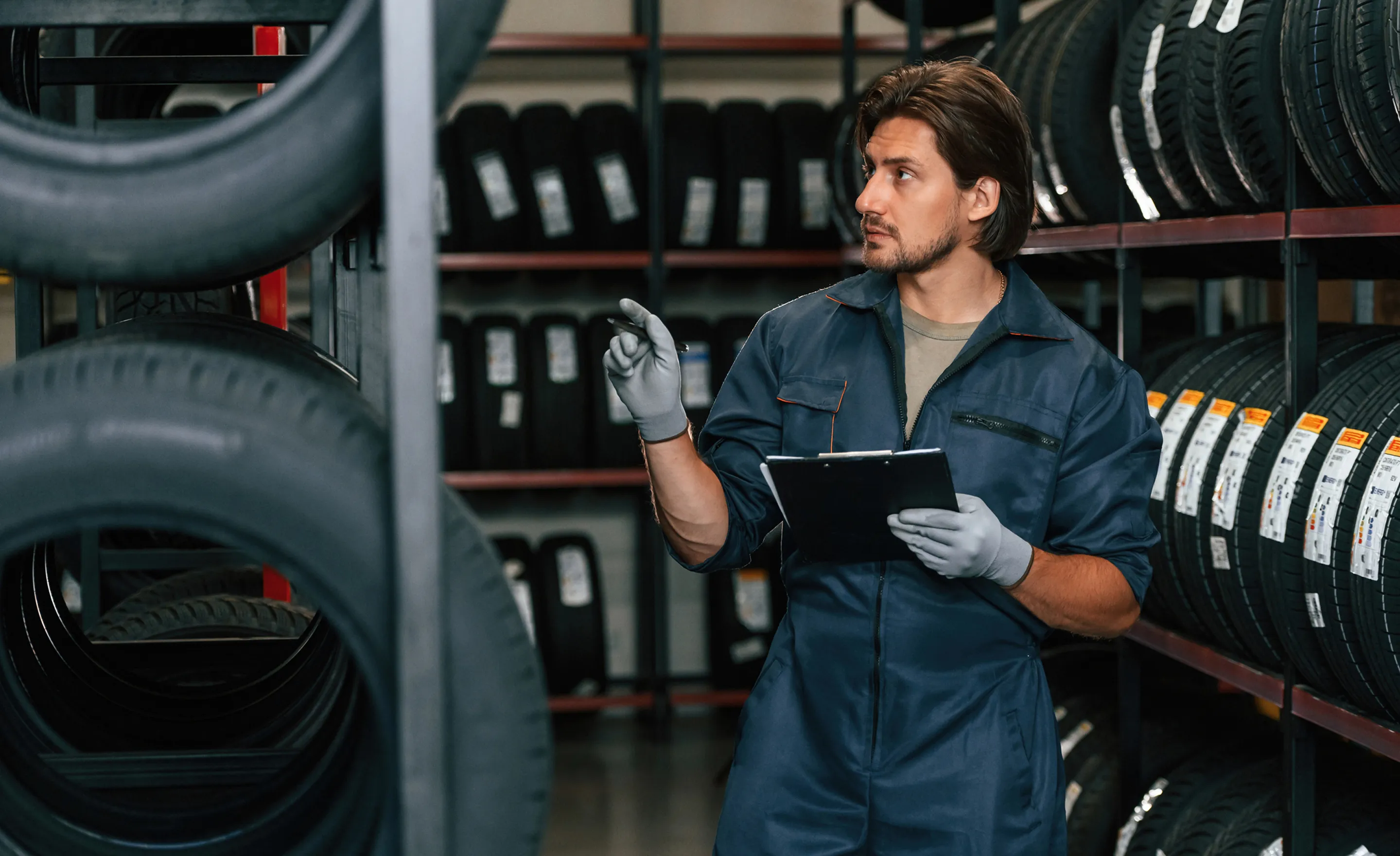 Un garagiste qui compte le nombre de pneu qu'il a dans son garage 