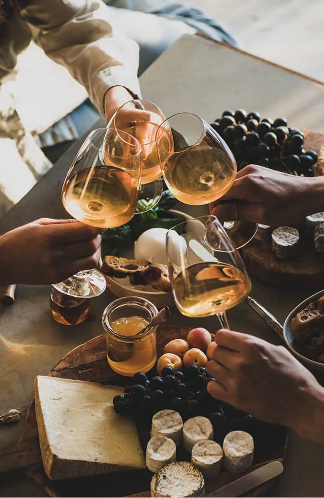 4 personnes qui trinquent avec des verres de vins