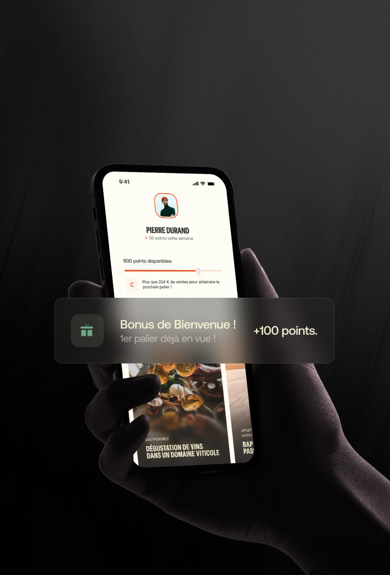 Hand holding smartphone displaying a user profile with points balance and a welcome bonus notification of +100 points in French.