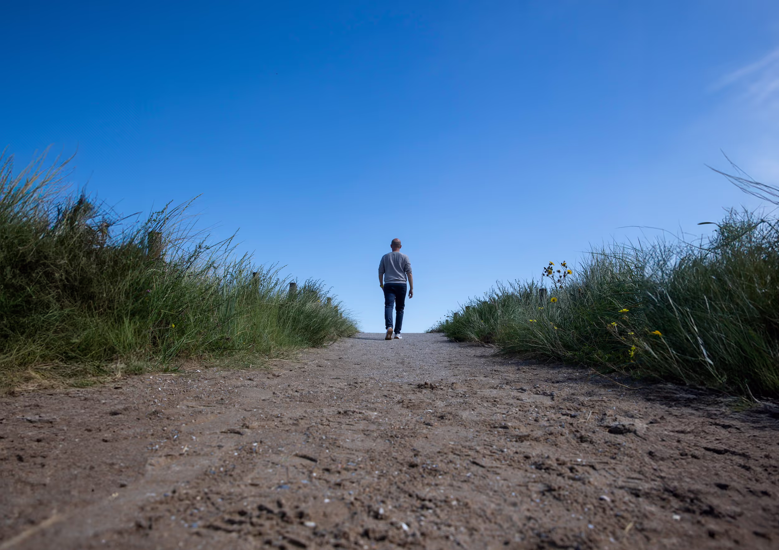 Man die door de duinen loopt.