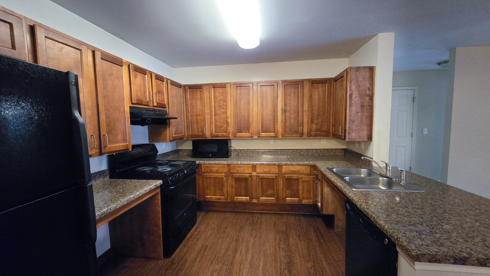 Kitchen with wood cabinets and black appliances
