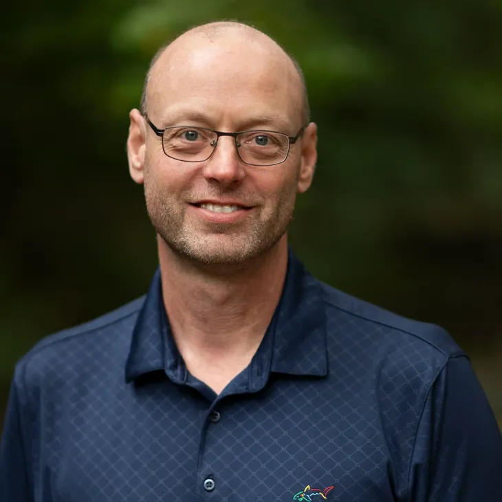 Head shot of Darren Sparks on a blur green background