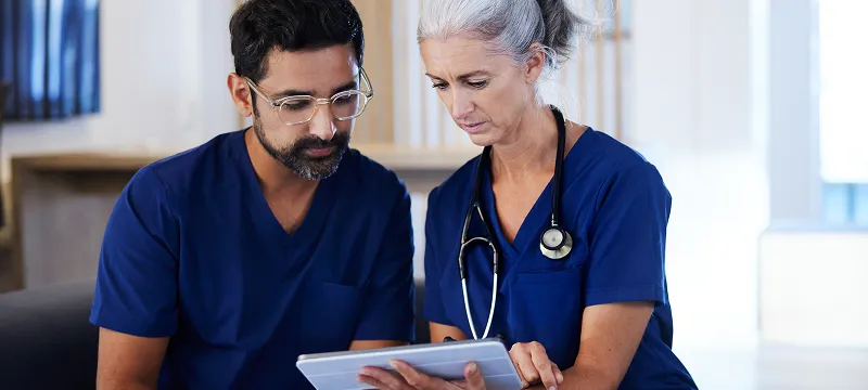 two doctors working together, looking at digital tablet