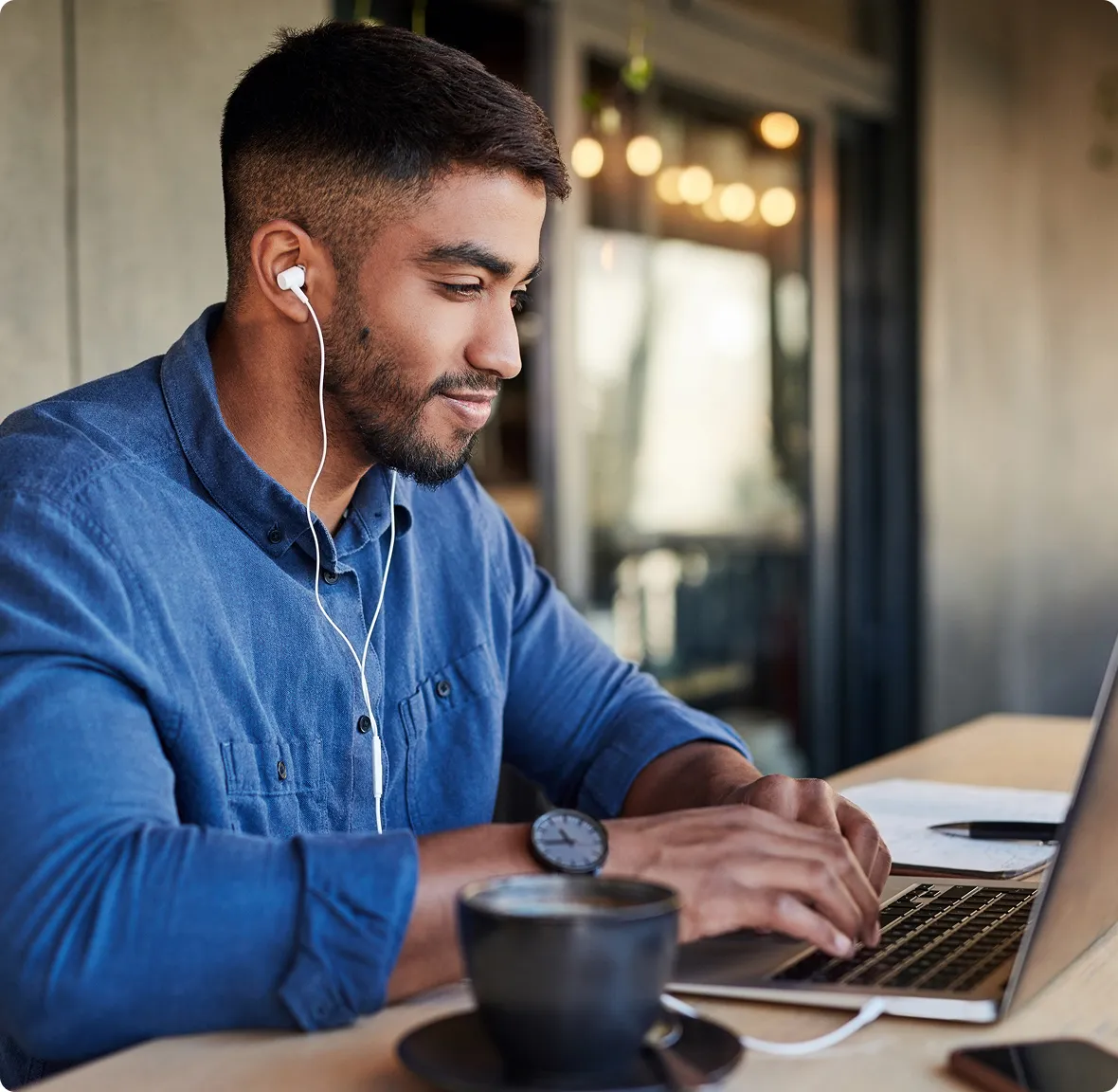 man studying on his laptop in an outdoor café