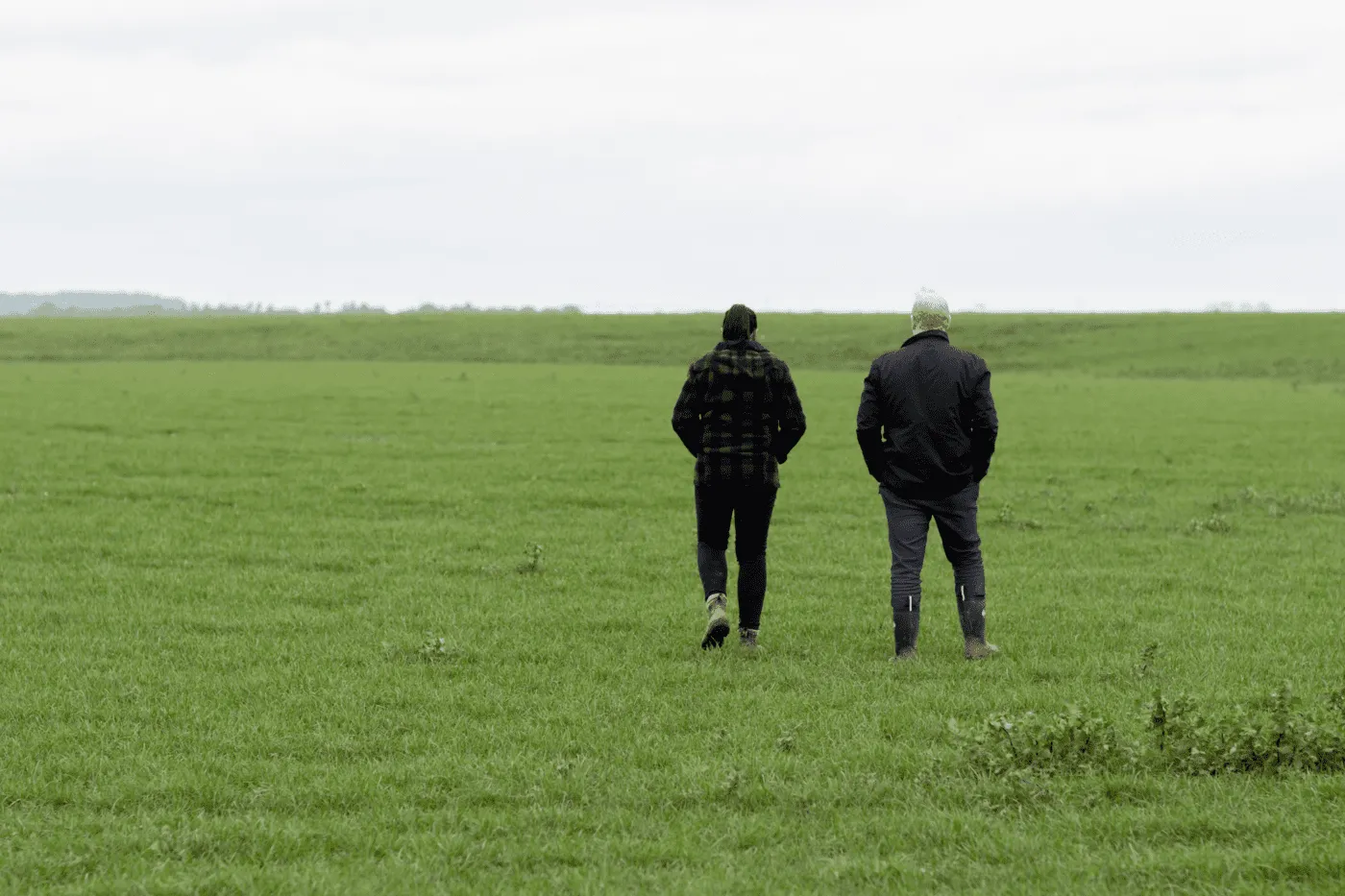 client with broker walking on farm land
