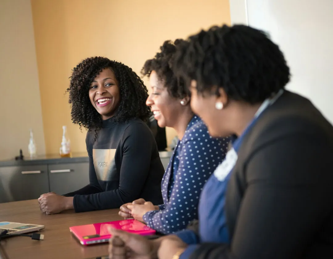 three women sitting beside wooden table