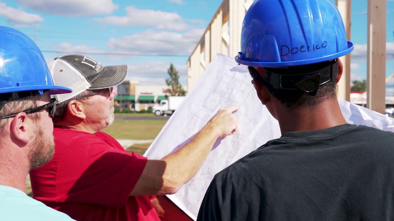 Local builders looking at a floor-plan for a new building.