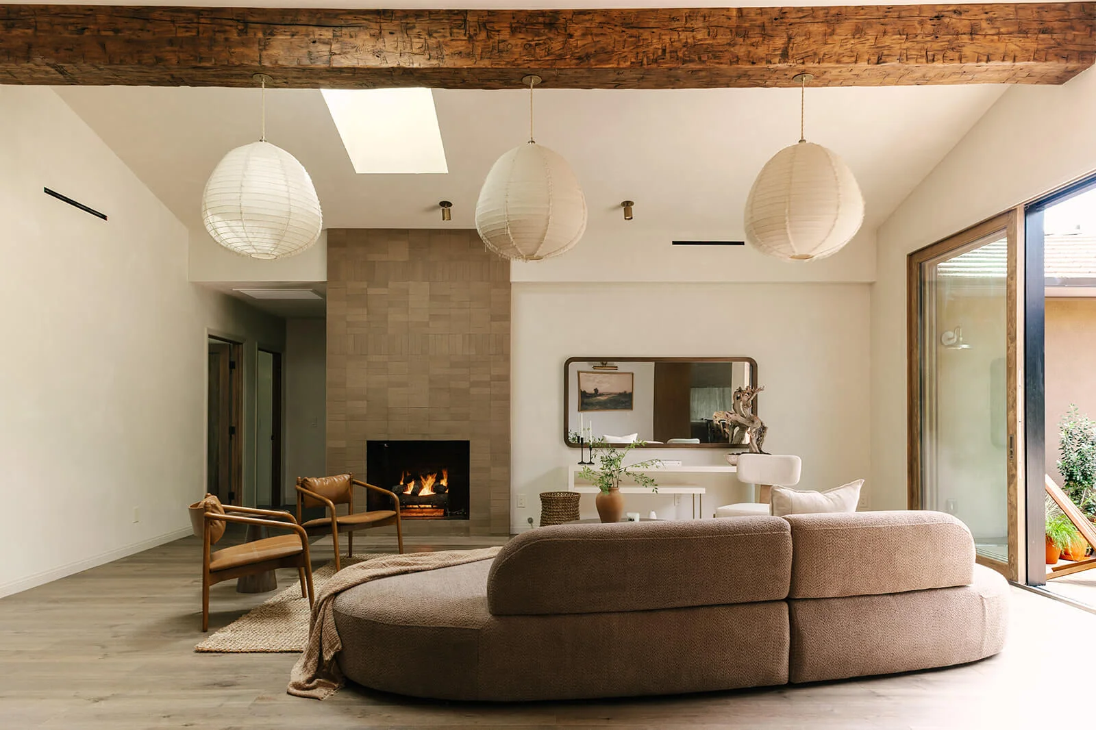 Modern kitchen with stainless steel stove, wooden cabinets, marble countertops, and open wooden shelves with jars and cutting boards.