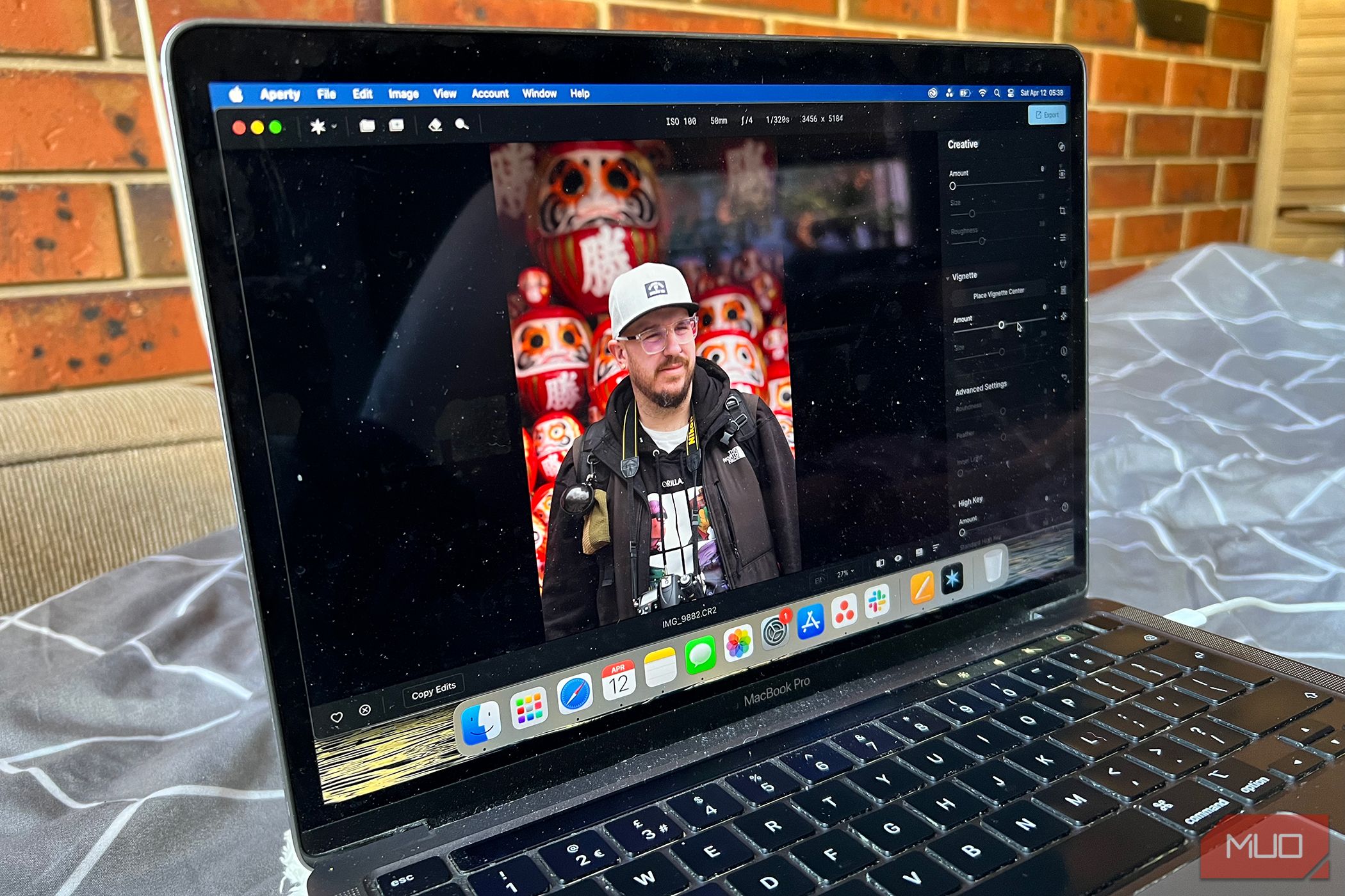 A MacBook displaying the Aperty photo editing app with enhanced portraits.