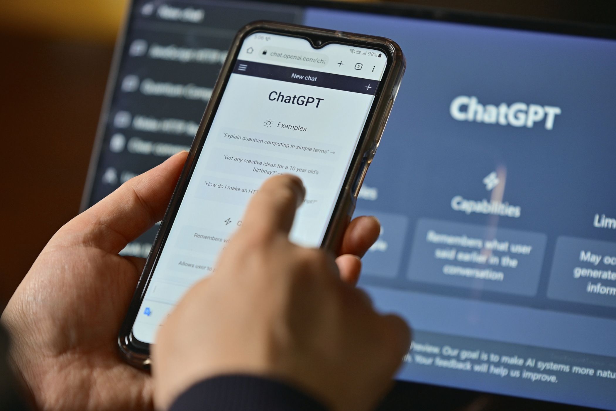 Person using ChatGPT on smartphone and laptop