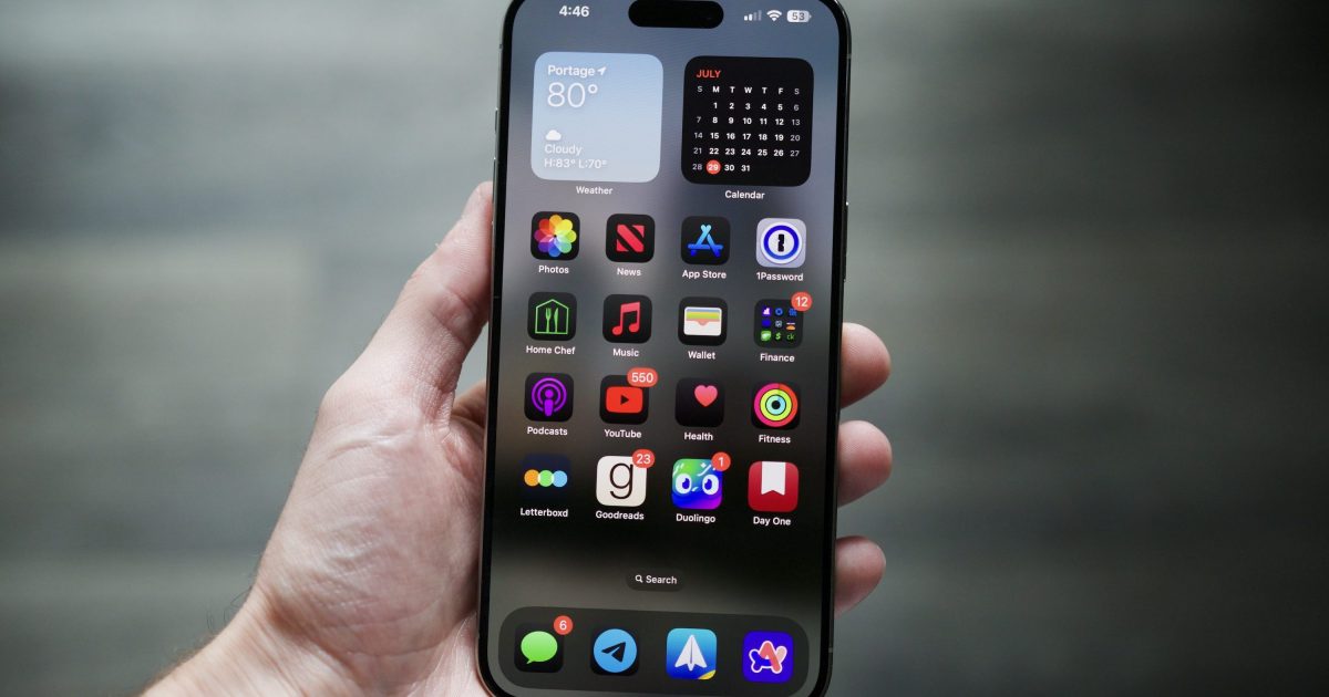 An iPhone displaying the new iOS 26 home screen.