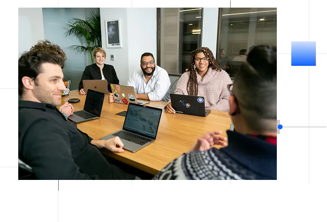 A group of people sitting in front of their laptops and talking