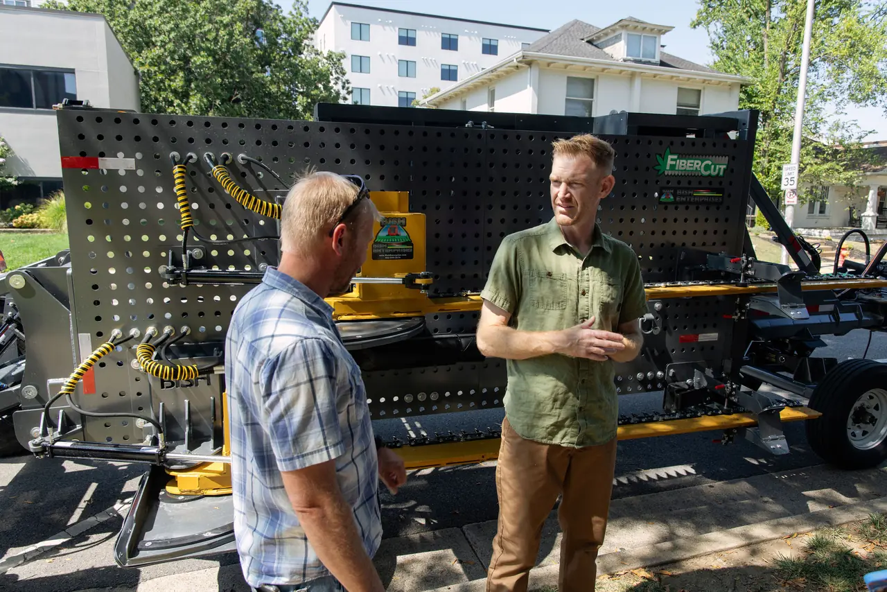 Clint Palmer talking with a client at a hemp equipment demonstration