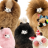 Four small poodles with fluffy coats styled into round shapes, each wearing a decorative accessory on their heads.