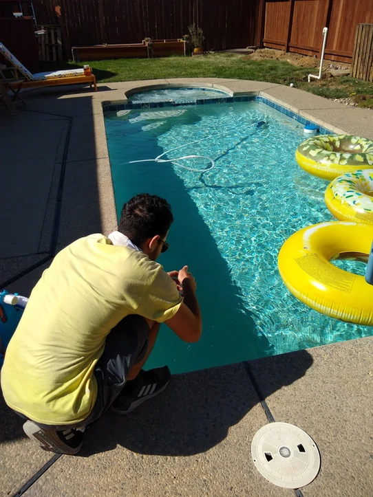 Pool technician performing routine residential pool care