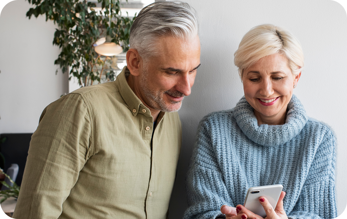 Mann und Frau lesen Informationen auf einem Mobiltelefon