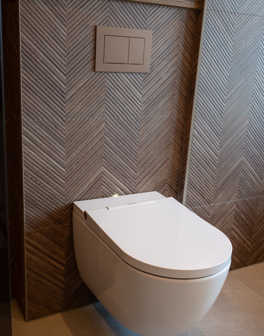 Douche-wc met dik deksel tegen een visgraatwand in houtlook
