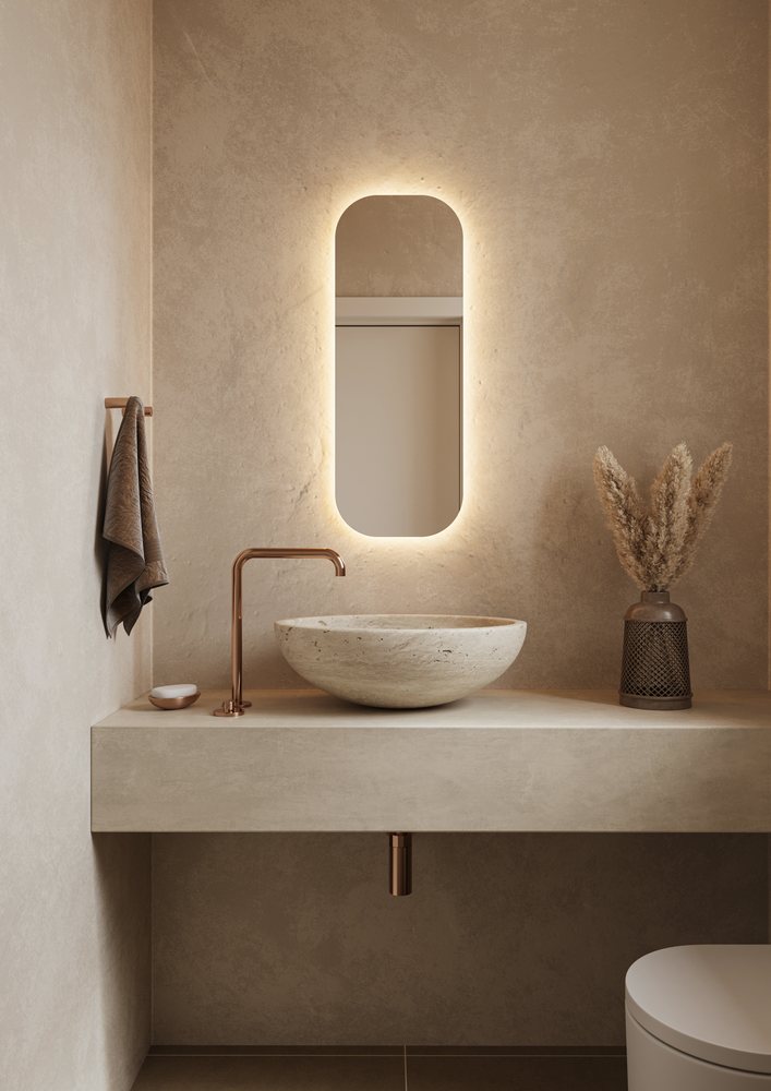 Beige steenlook toiletruimte met een hoge verlichte spiegel en een natuurstenen blad