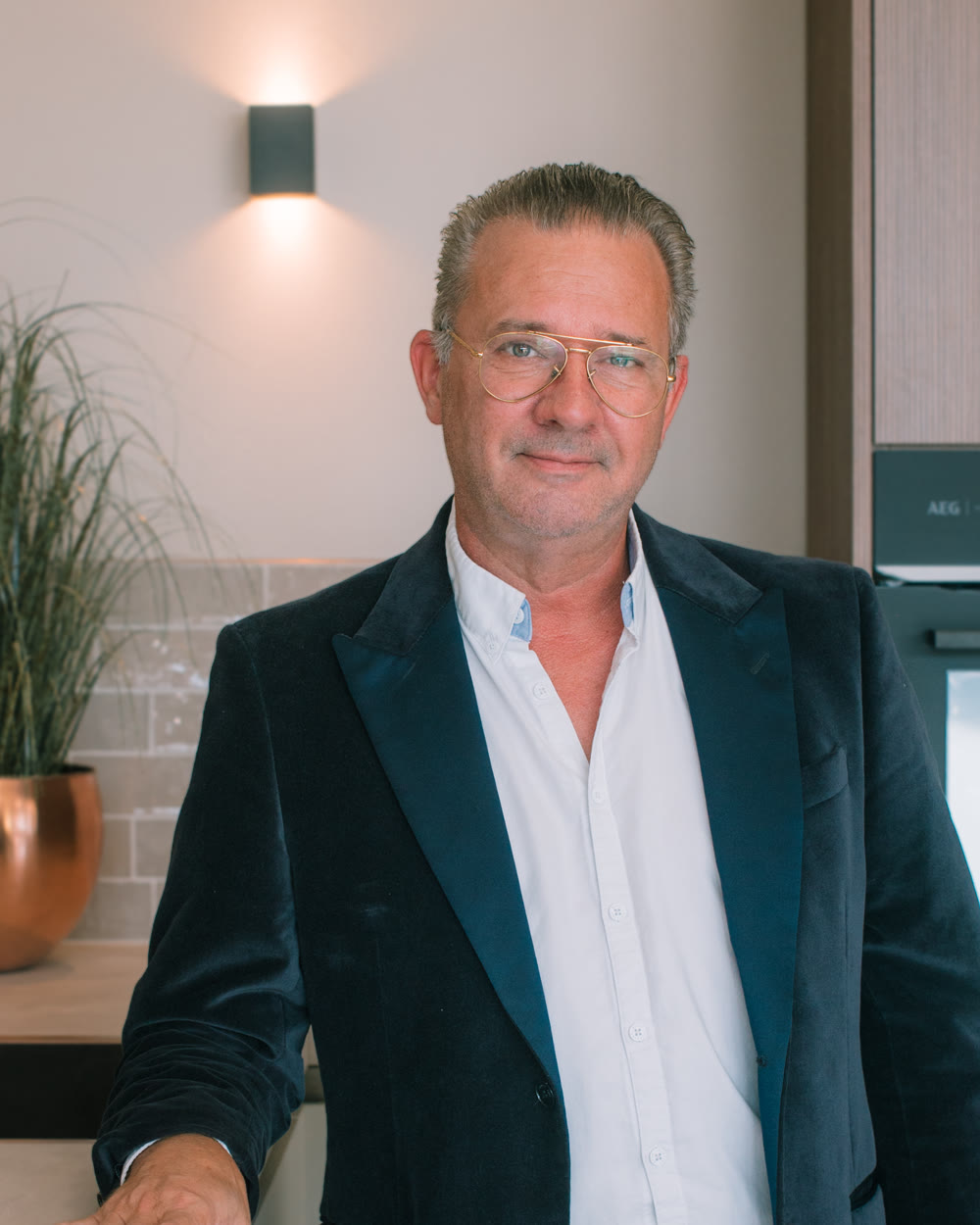 Adviseur van Mega in de keukenshowroom, naast een keuken met houtlook fronten