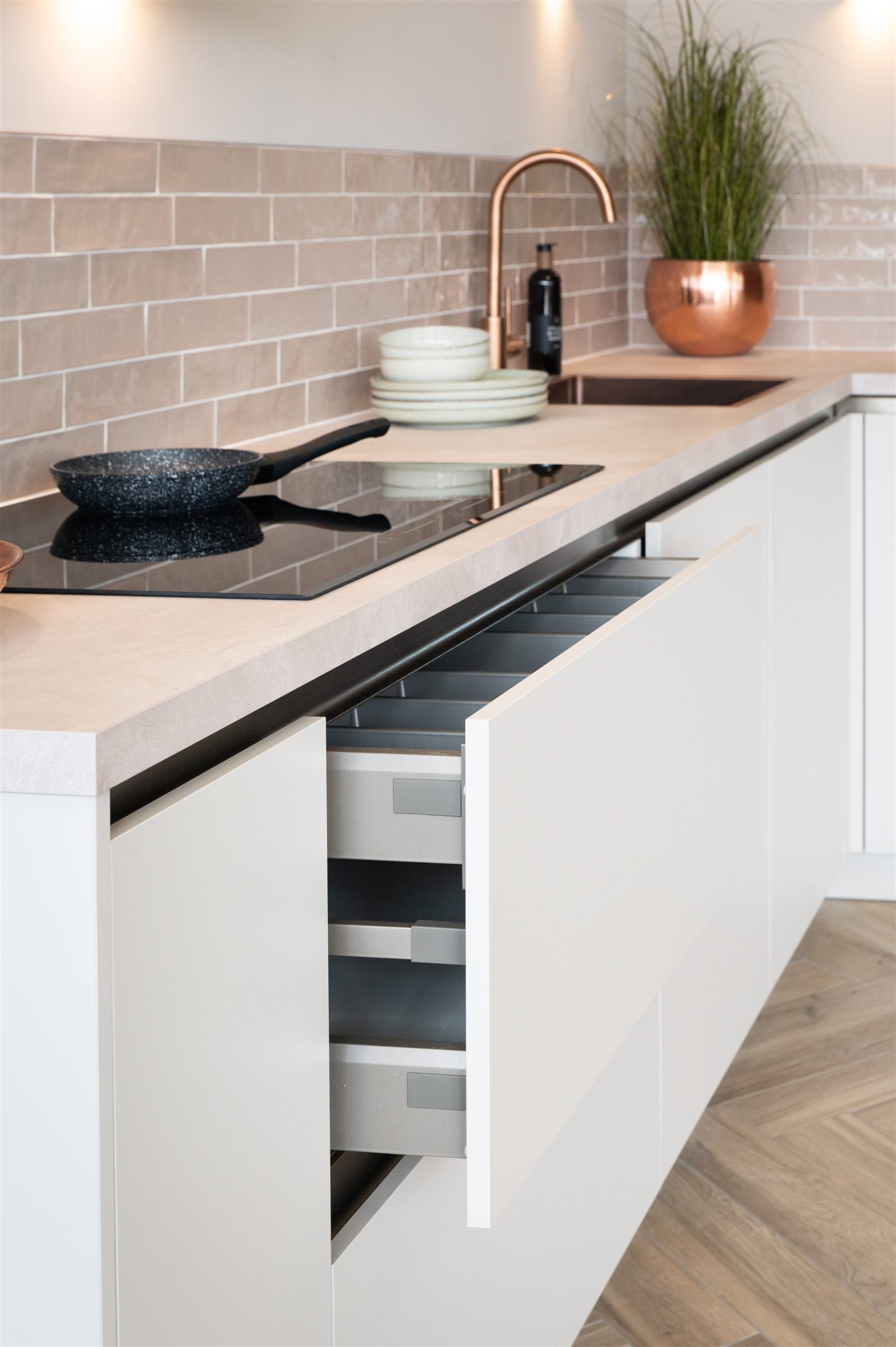 Greeploze lades en koperen kraan in een moderne keuken