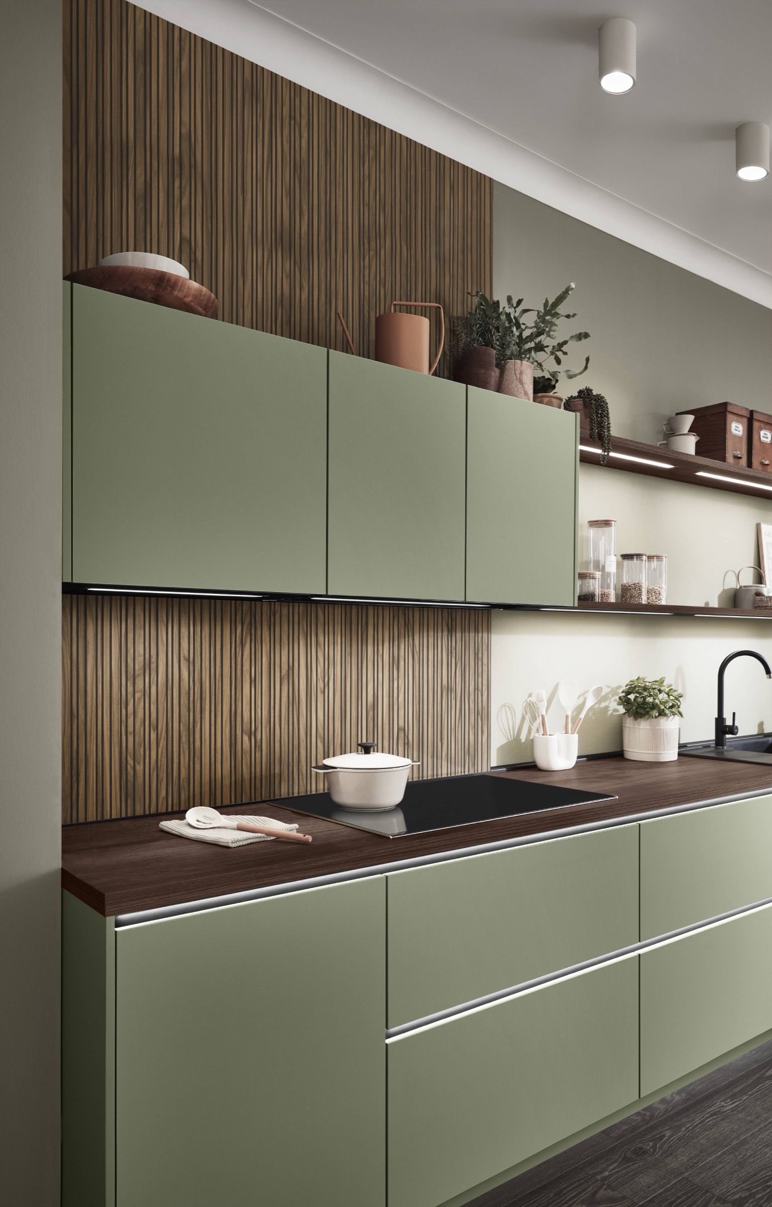 Olijfgroene greeploze keuken met walnoot lamellenwand en donker houten werkblad
