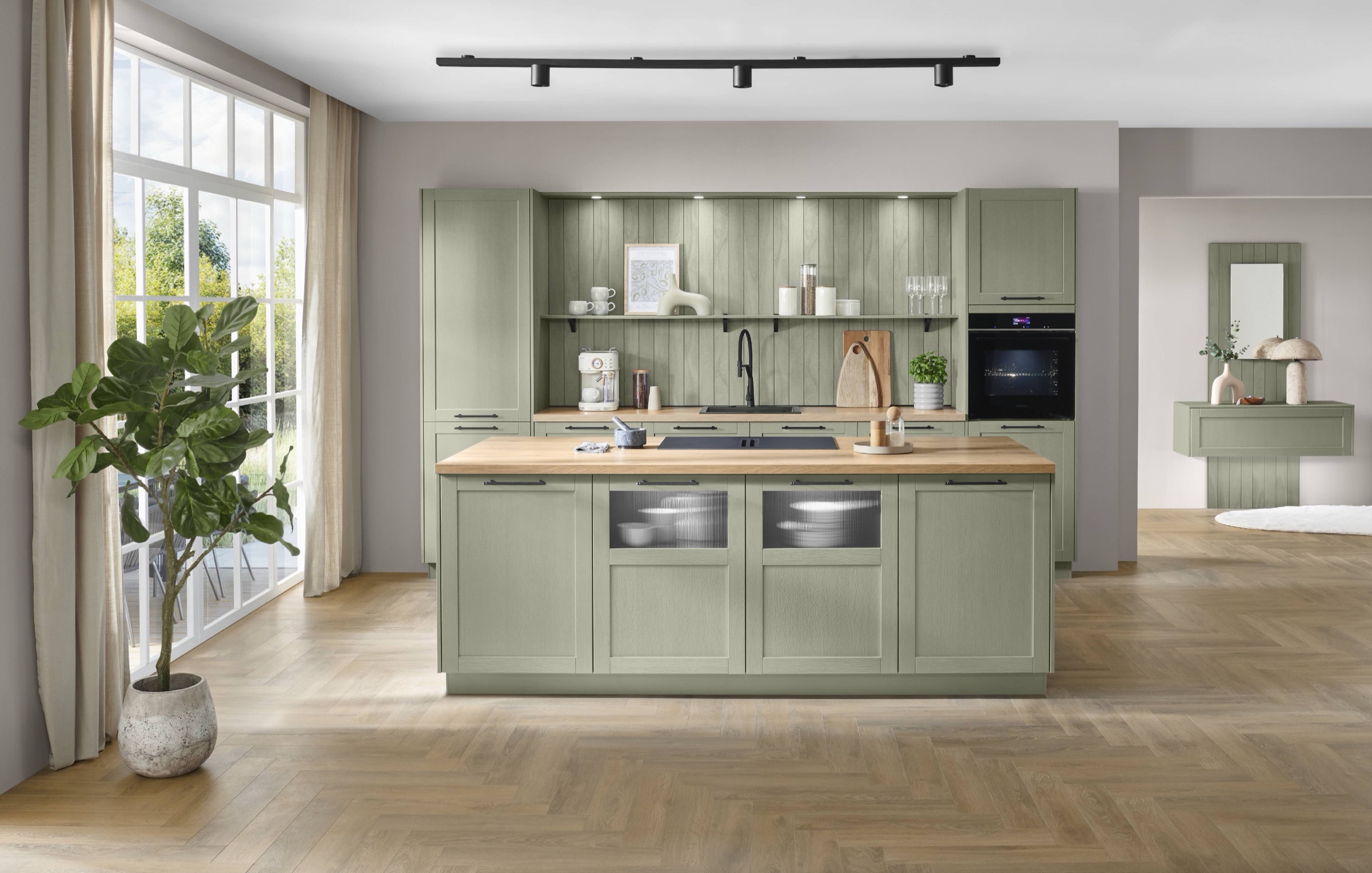 Groene keuken met saliegroene kaderfronten, kookeiland met eiken blad en visgraatvloer