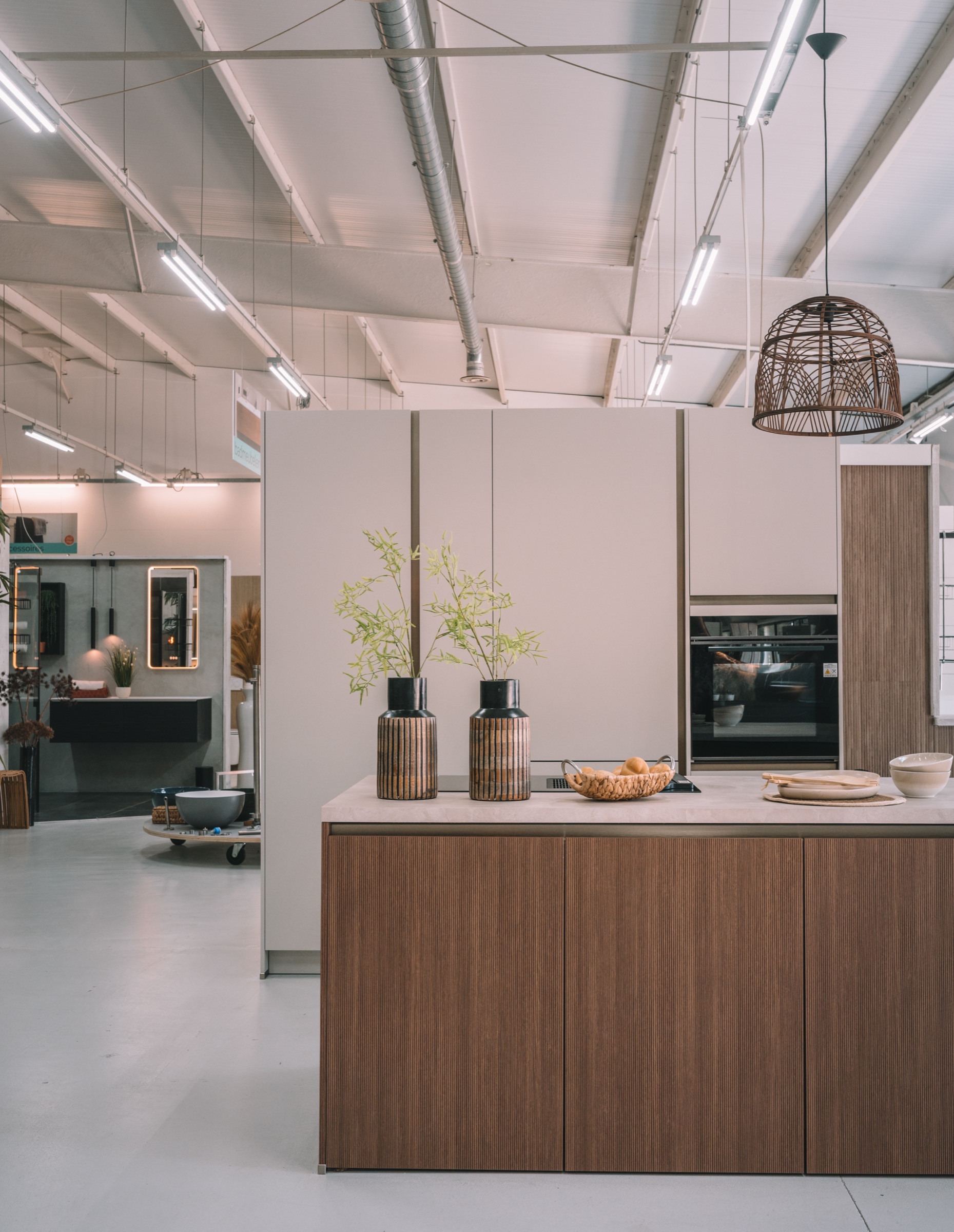 Japandi keukeneiland met ribbelfront, taupe kastenwand en koperen kraan in de Mega showroom