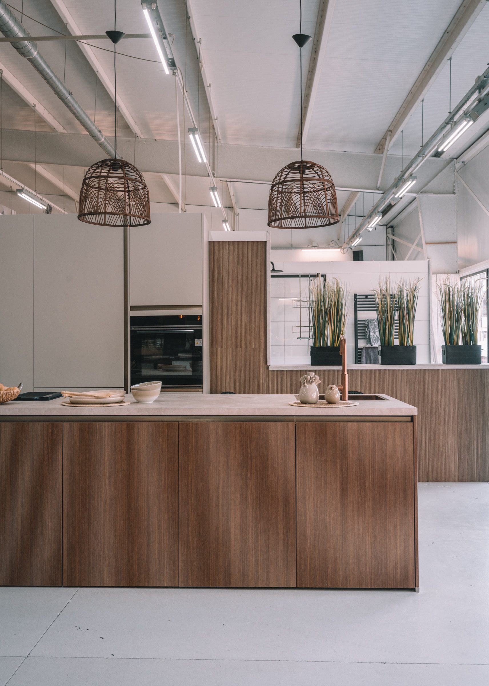 Japandi keuken met walnoot ribbelfront eiland en rotan hanglampen in de Mega showroom