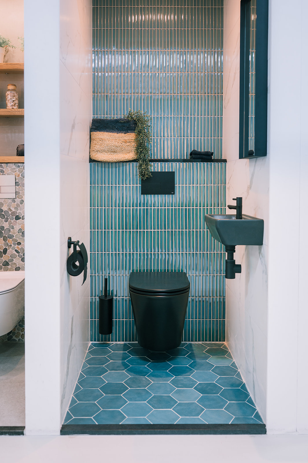 Turquoise strokentegels en hexagontegels in een toiletruimte