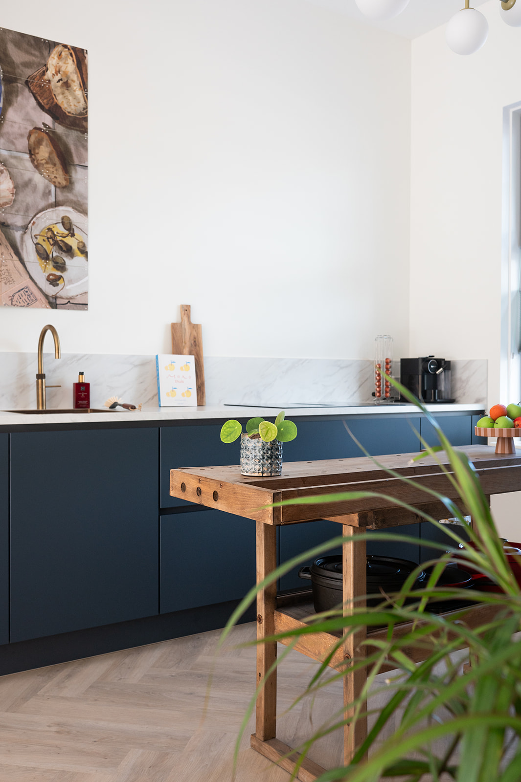 Blauwe keuken met plant en eettafel