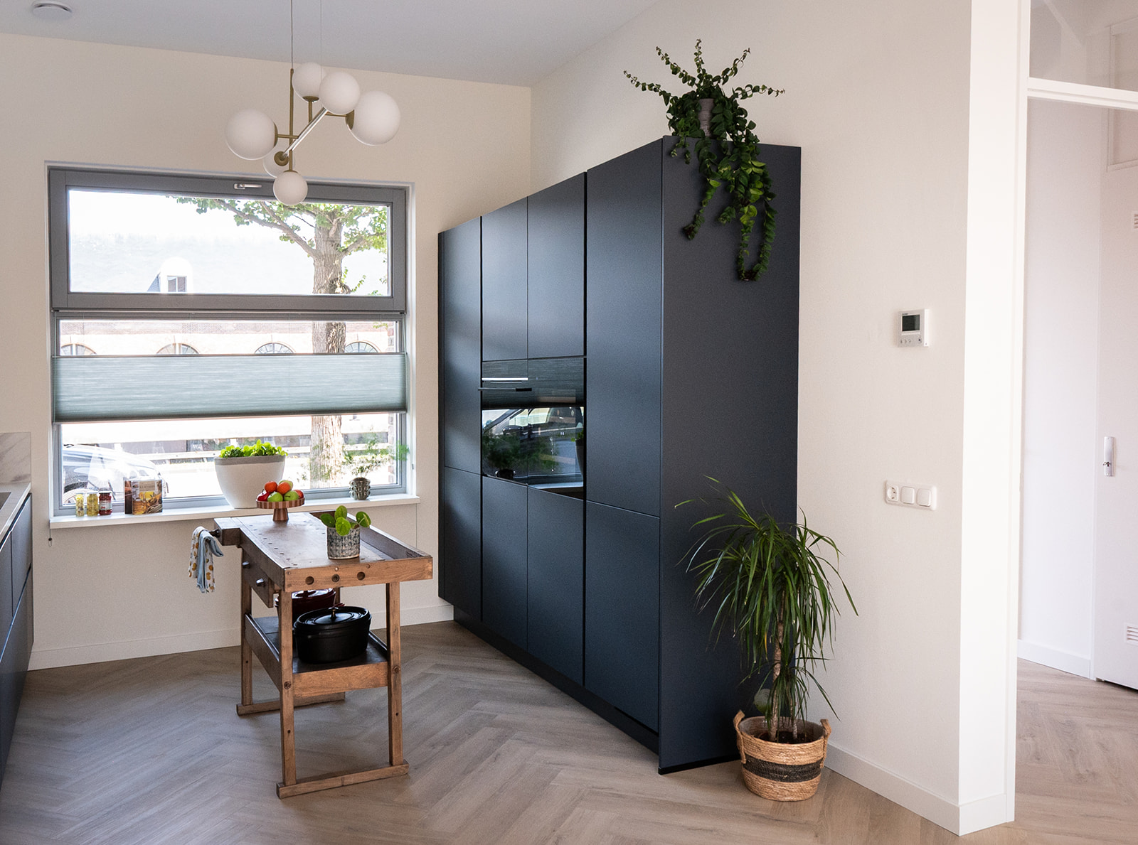 Blauwe keuken met hoge kastenwand