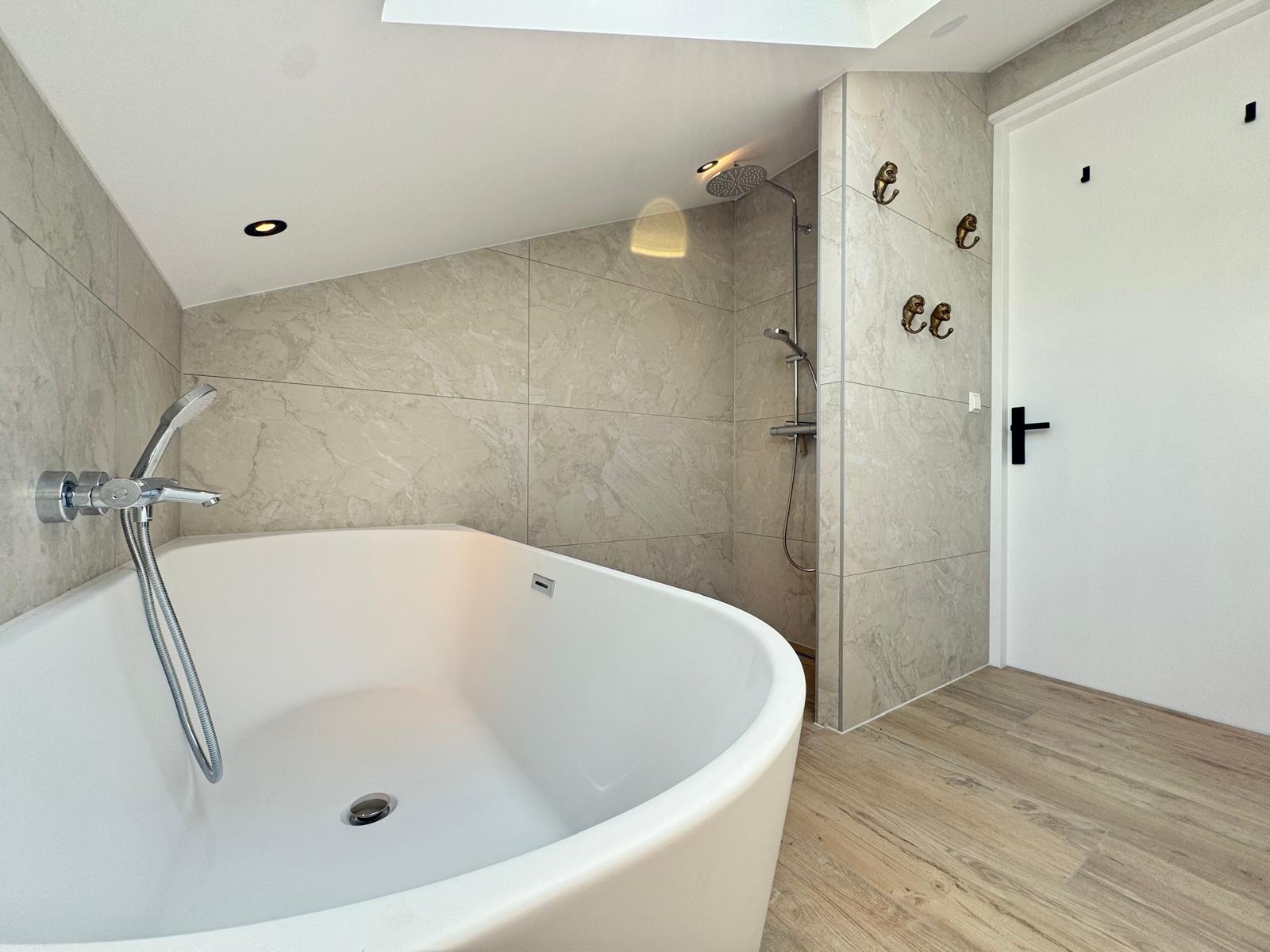 Vrijstaand bad in betonlook badkamer