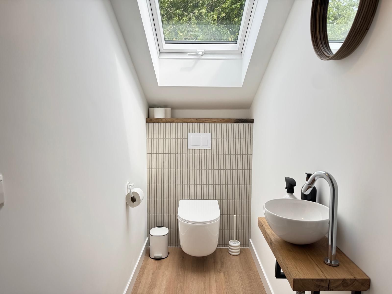 Wandcloset en bidet onder dakraam