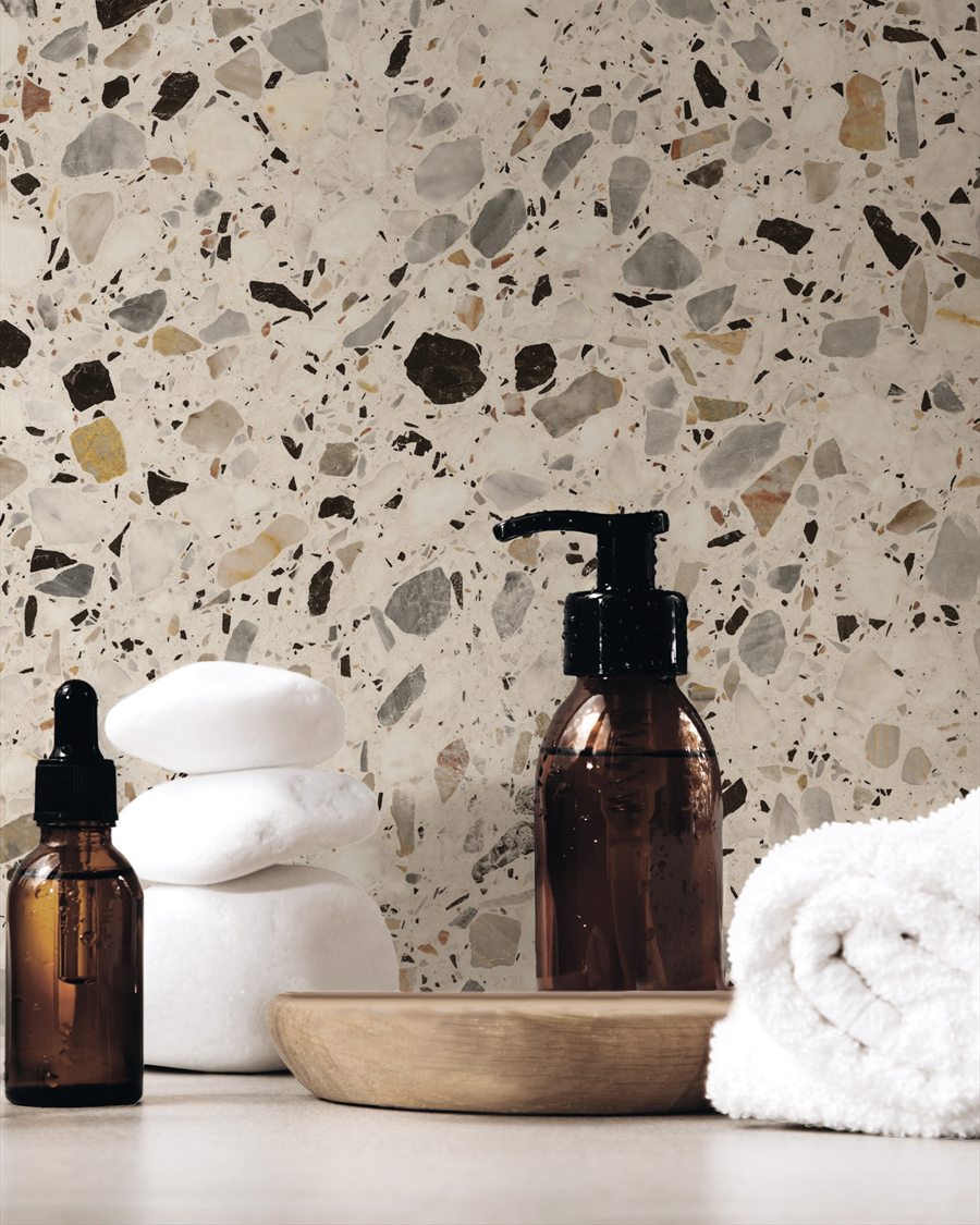 Detailopname van terrazzolook tegels met badkameraccessoires op een plank