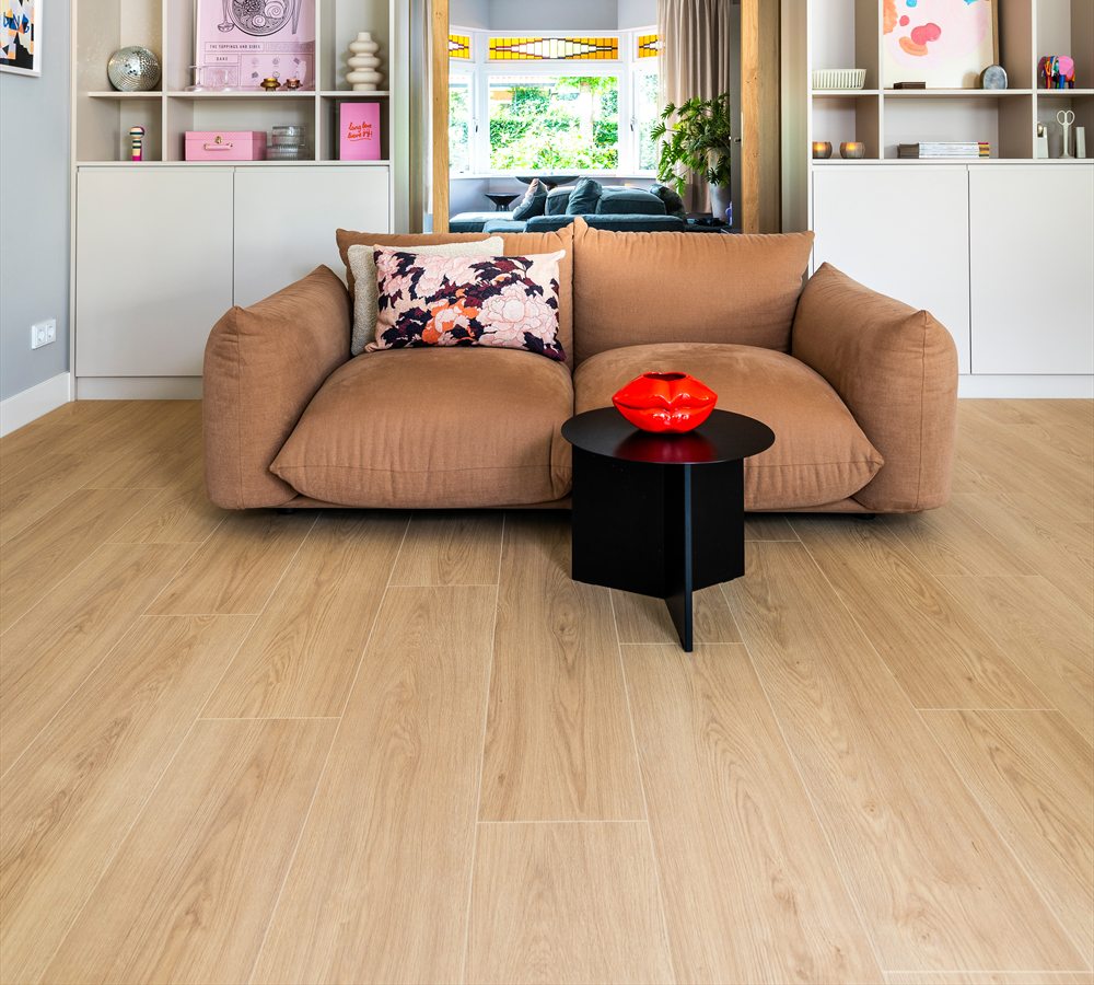 Woonkamer met een lichte plankenvloer voor een kastenwand met open vakken