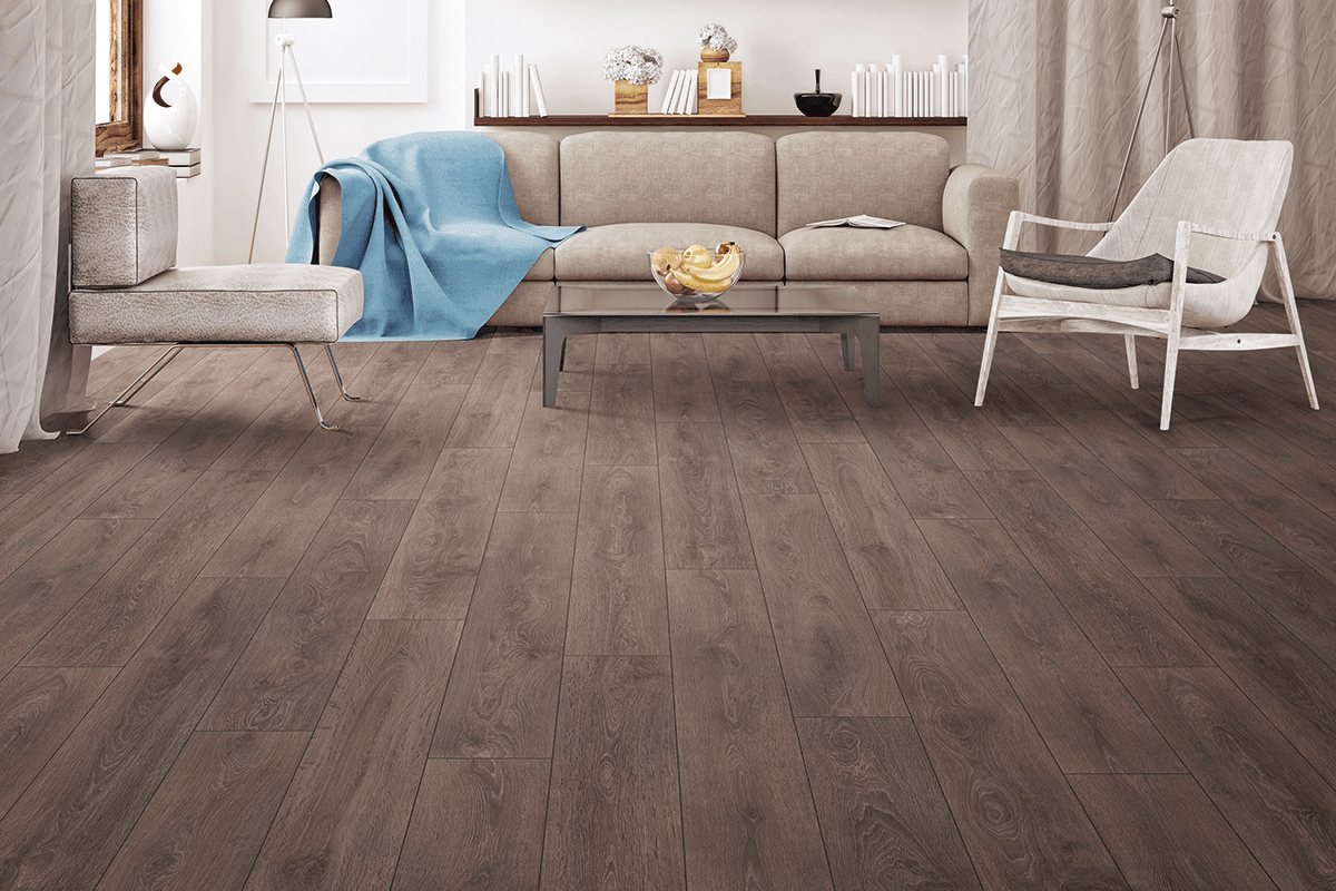 Woonkamer met een donkere plankenvloer, een lichte bank en een witte fauteuil