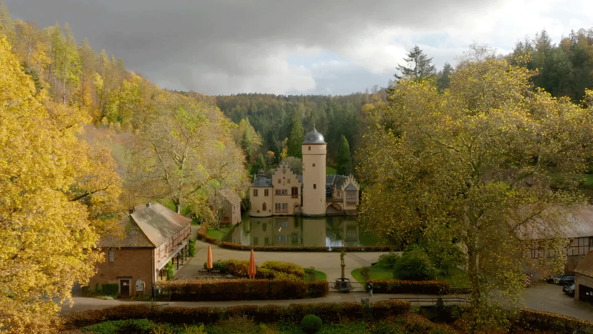 Drohnenaufnahme eines Schlosses mit einem kleinen See
