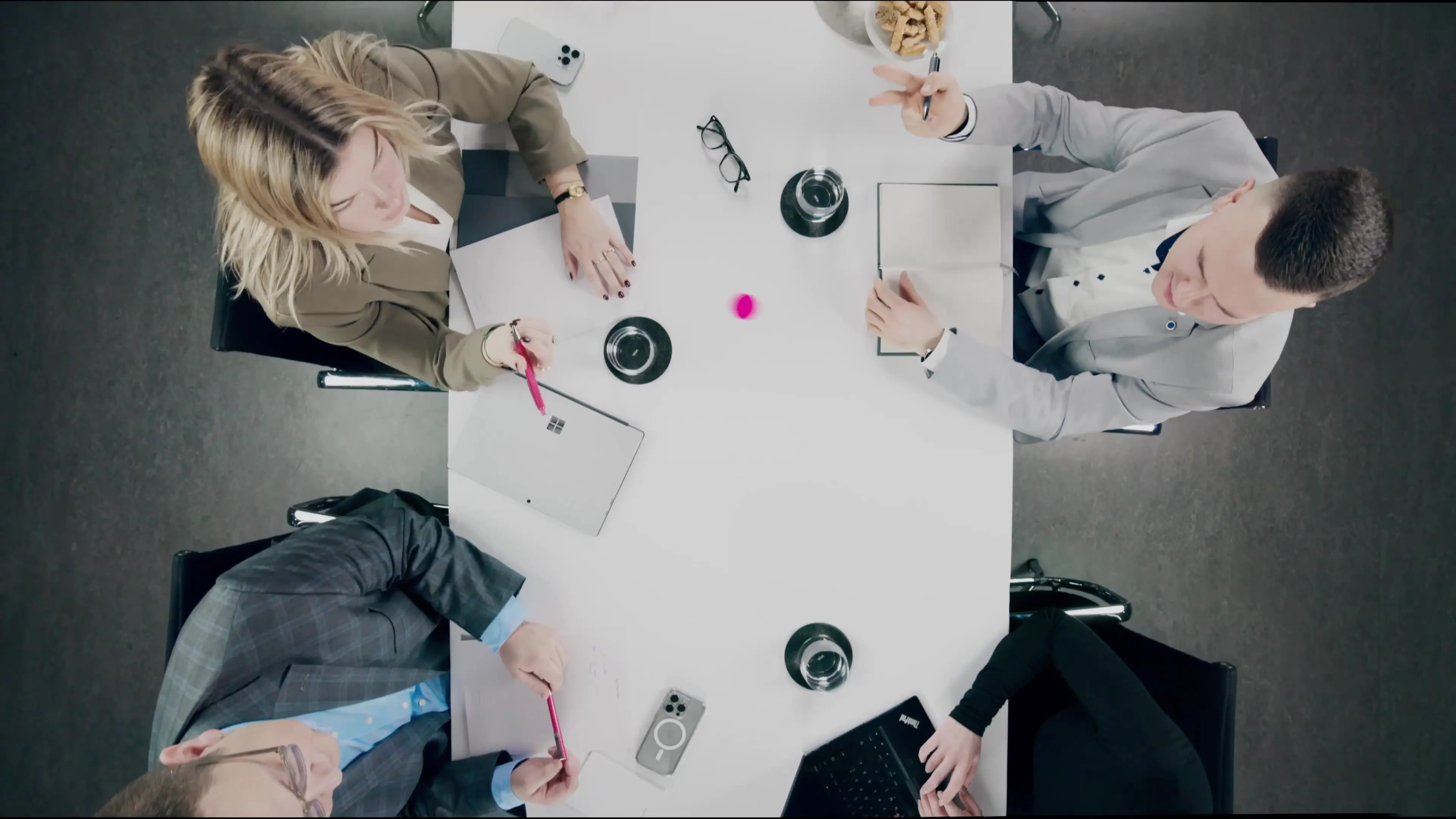 Ein Tisch von oben an dem 4 Personen sitzen.